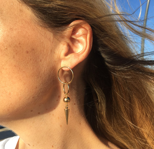 Boucles d'oreilles pendantes, enchainement d'anneaux, d'une perle dorée et d'un pic ppour une allure rock sophistiquée
