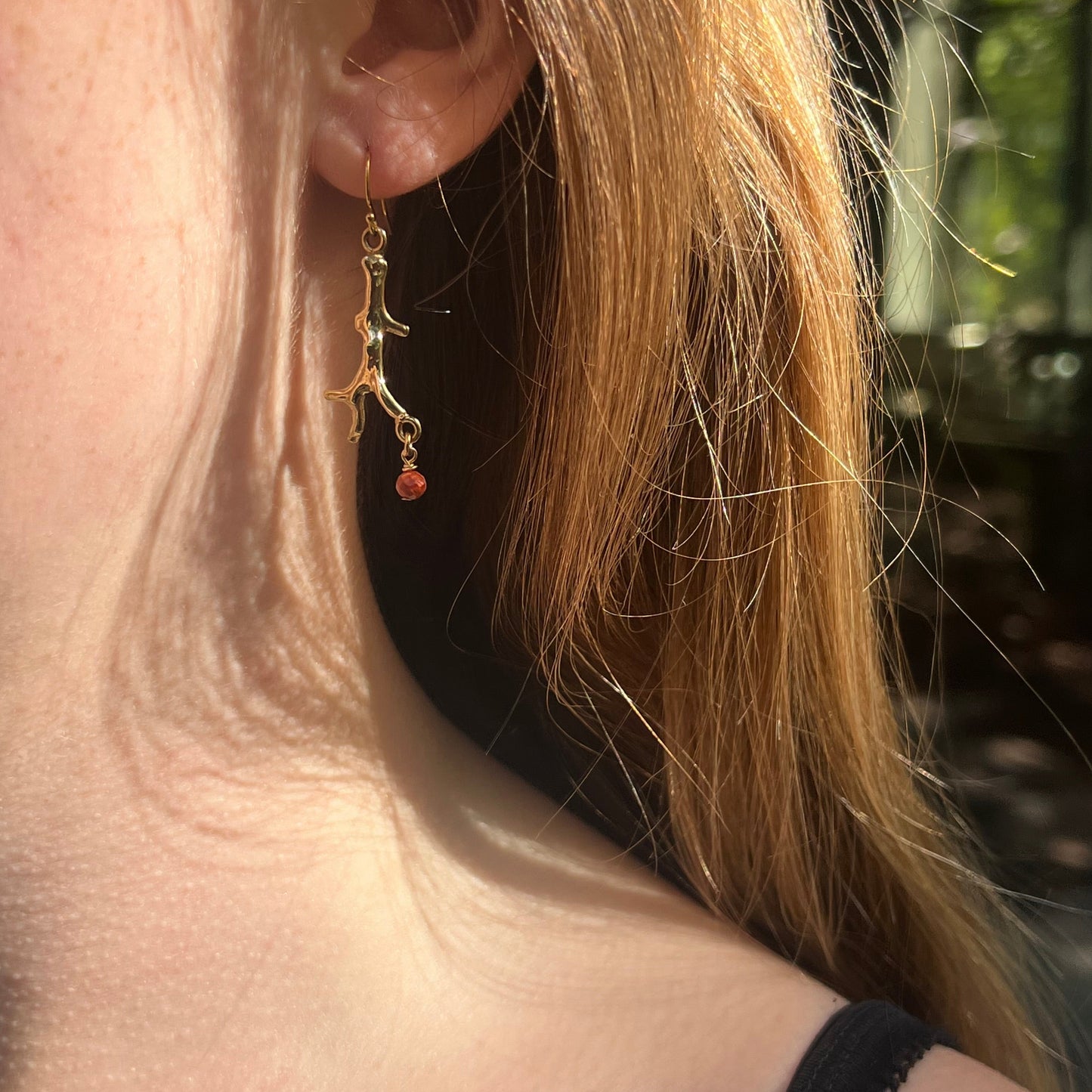 Boucles d’oreilles en branches de corail dorées avec perles rouges qui pendent 